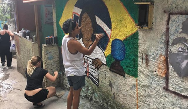 volunteer painting orphanage wall