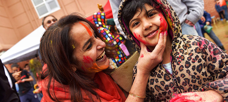 volunteer applying color to children during holi